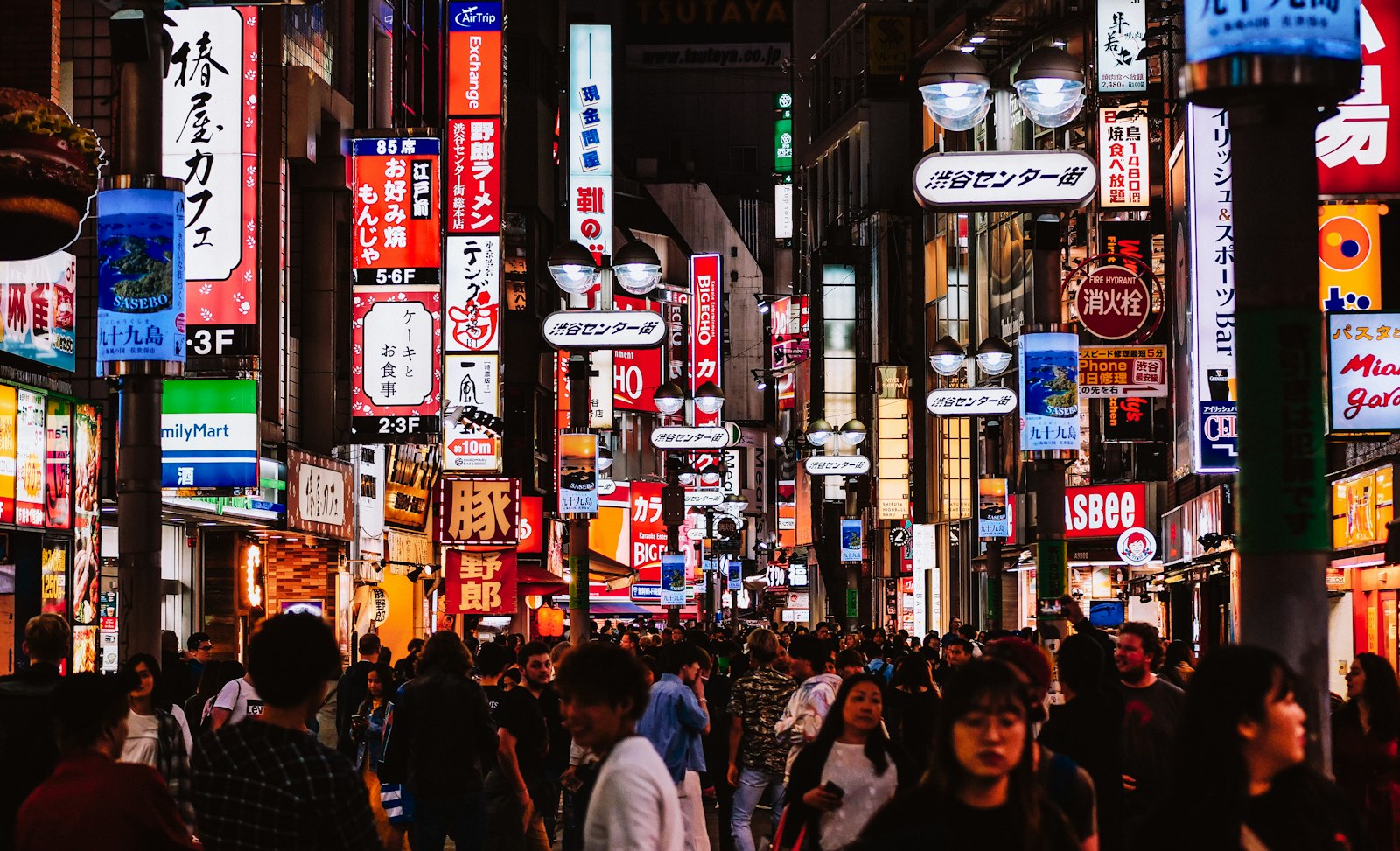 Group of friends walking down a neon-lit Shinjuku street at the start of a Tokyo bachelor party night