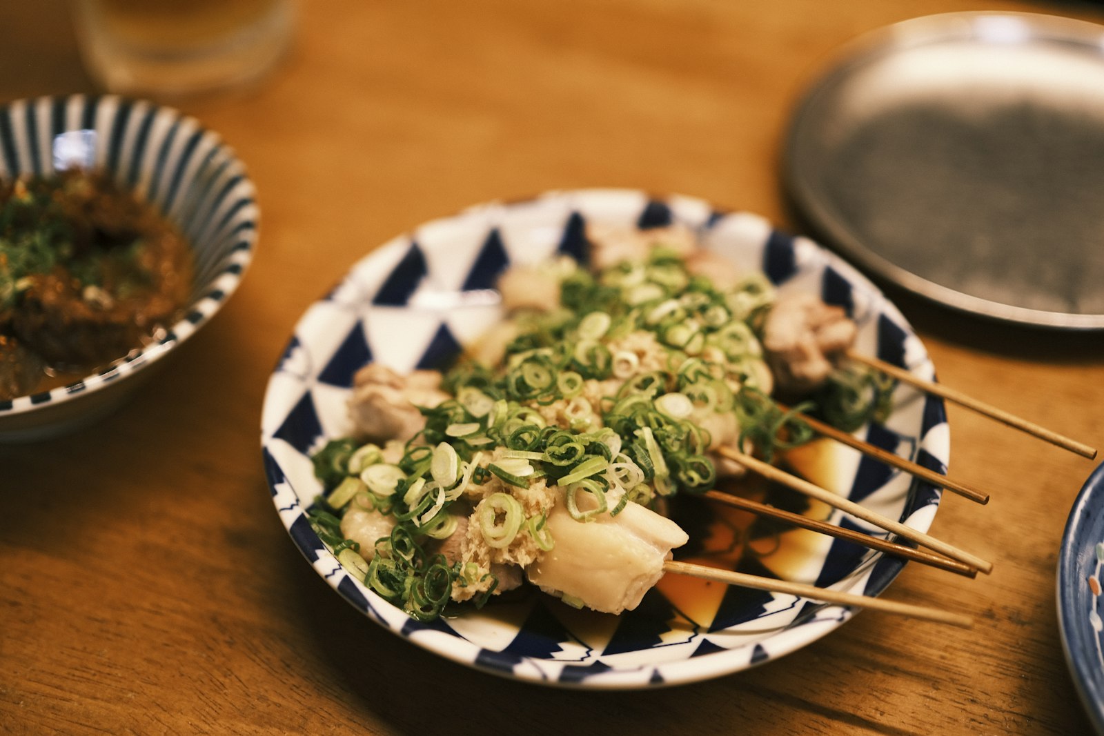alt: Charcoal-grilled yakitori skewers at a Tokyo street food night counter