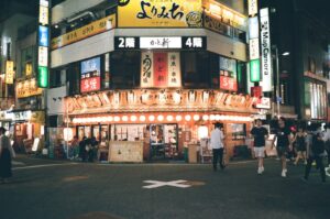Warm-lit izakaya interior in Tokyo with red lanterns and counter seating