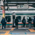Late-night commuters waiting on a Tokyo train platform before the last train departs