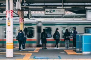 Late-night commuters waiting on a Tokyo train platform before the last train departs