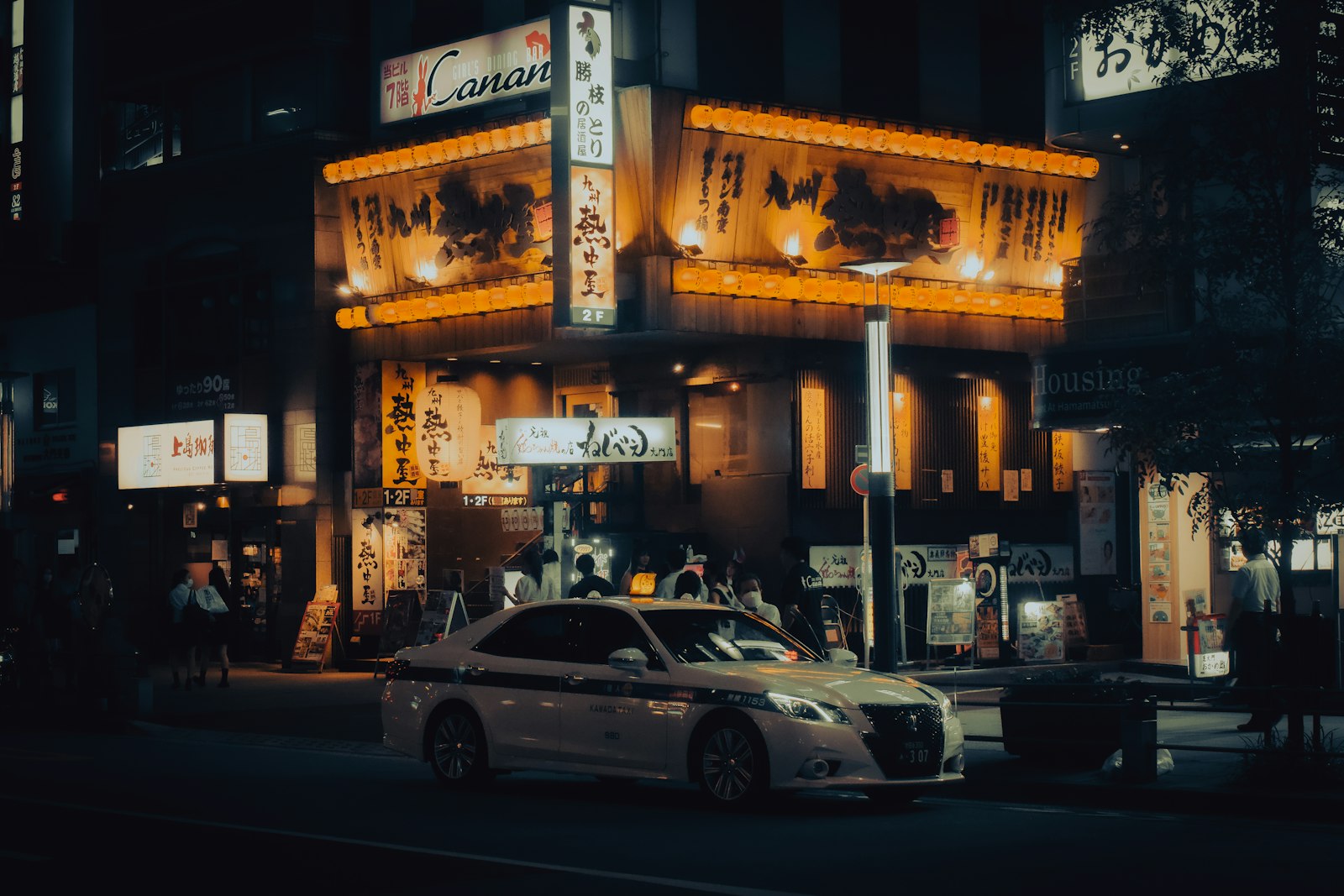 Tokyo taxi waiting on a neon-lit street after the last train has stopped running