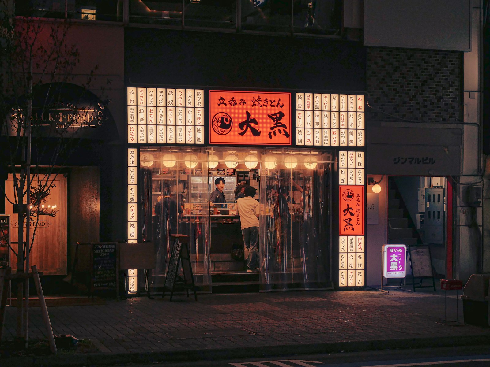 Skewers on the grill at a small counter during a night food walk in Tokyo