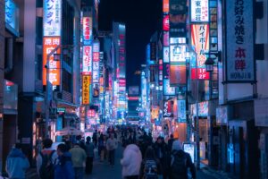 Foreign tourists walking down a neon-lit Shinjuku street on a Tokyo night tour