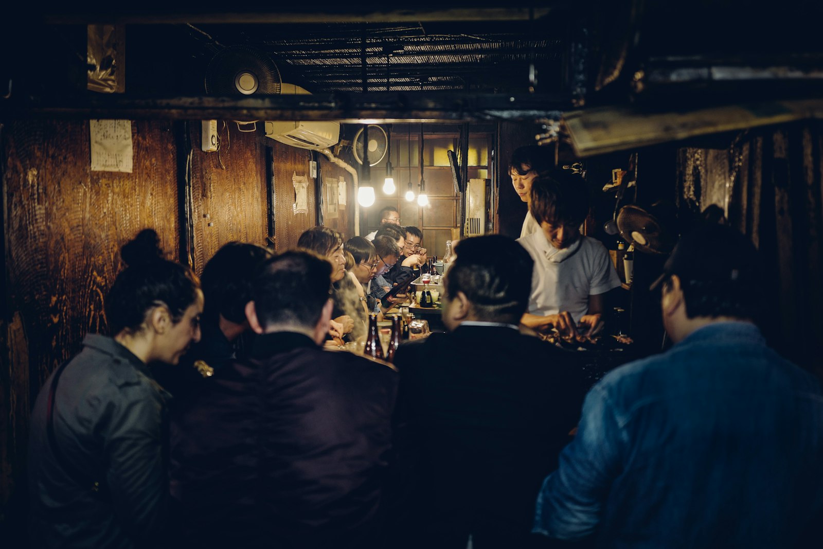 Narrow Golden Gai alley in Shinjuku lined with small bars, a popular stop on English-guided night tours