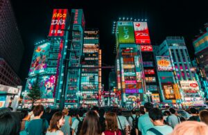 Group of friends walking under the neon signs of Shinjuku on a Tokyo night tour