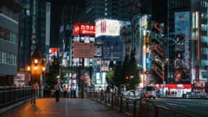 A solo traveler walking through a neon-lit Shinjuku street at night