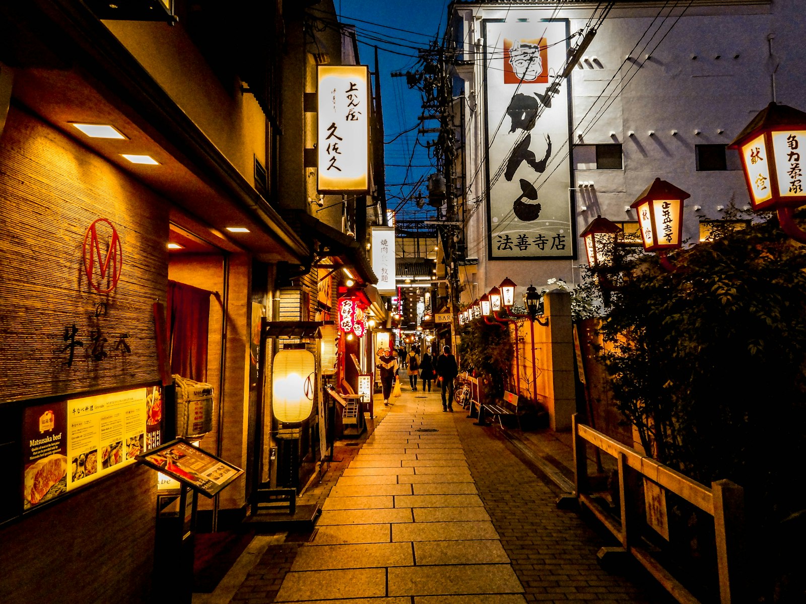 Narrow alley of tiny bars in Shinjuku Golden Gai at night, a highlight of many Tokyo bar hopping tours