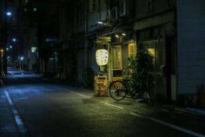 Handwritten Japanese bar signs in a narrow Shinjuku alley at night, the kind of doorway this Tokyo nightlife English guide helps you decode