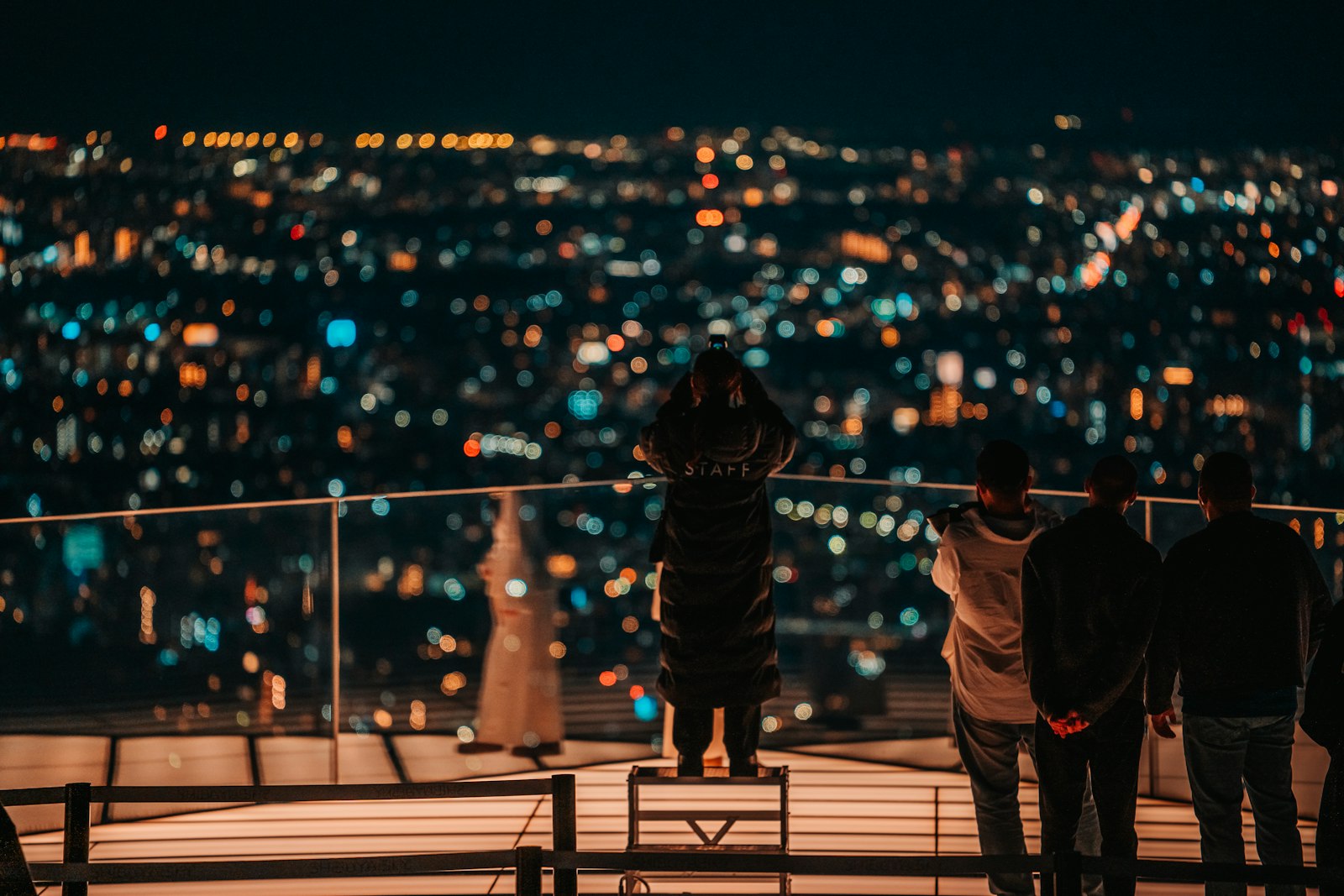 A couple looking out over the Tokyo skyline at night from an observation deck