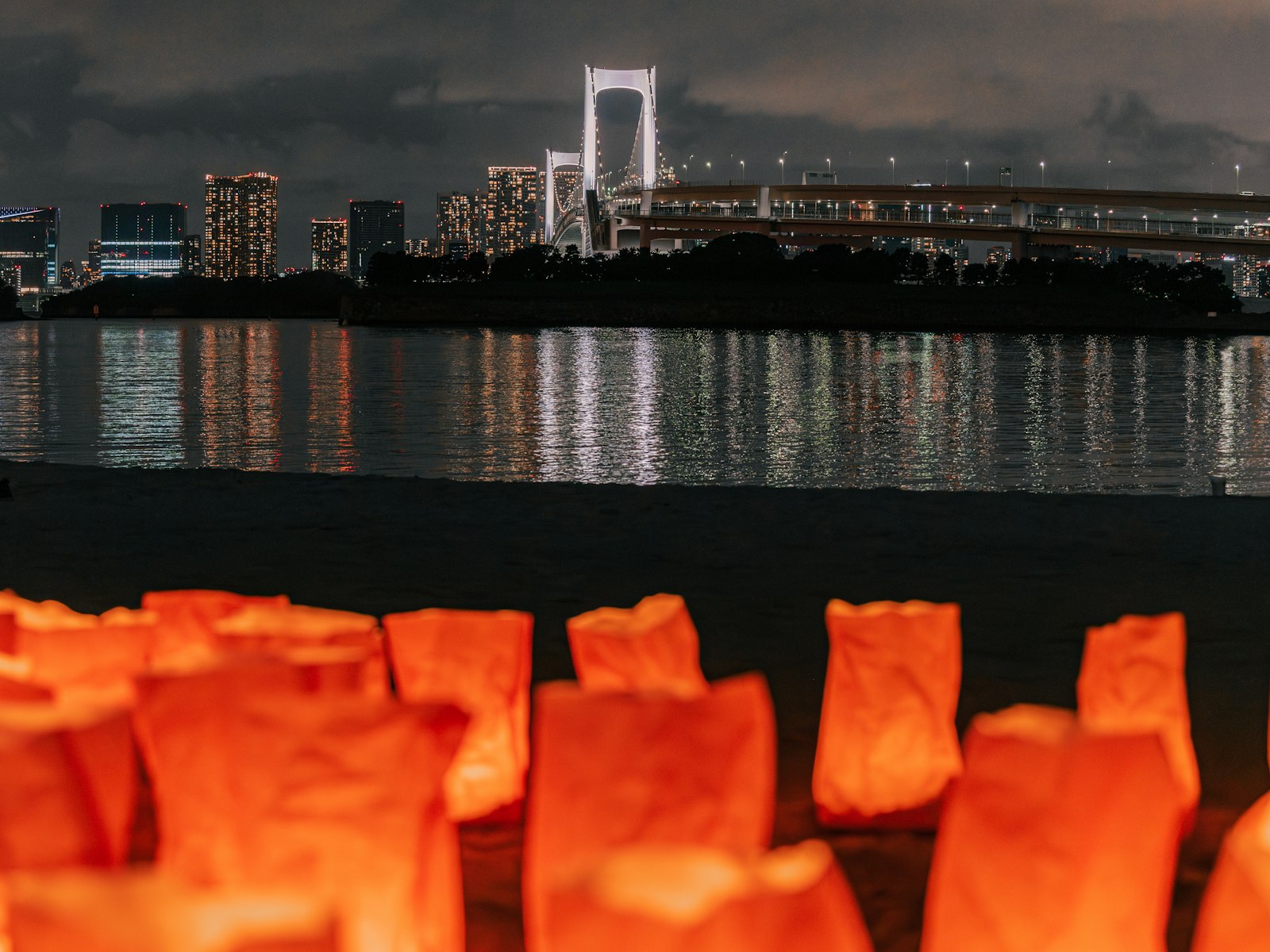 A traditional yakatabune boat with glowing lanterns on the Sumida River in Tokyo at night