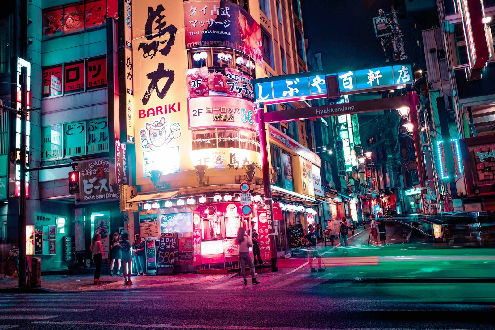 Crowds walking along a neon-lit Tokyo nightlife street after dark