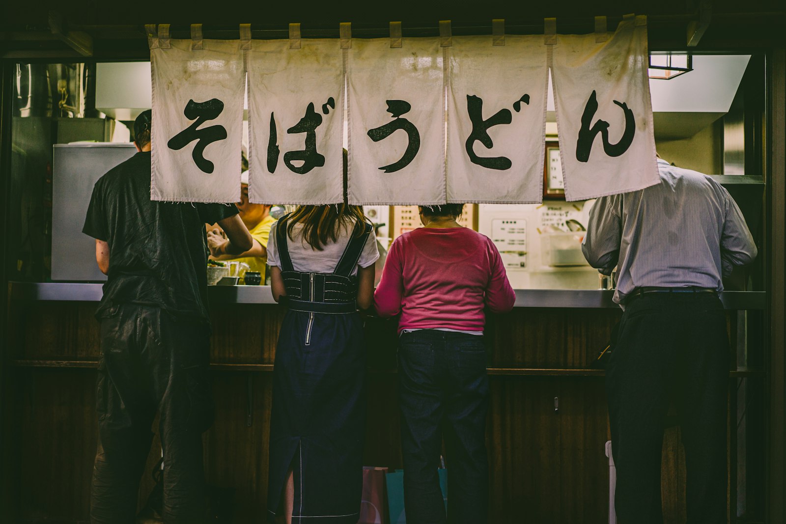 Small group of travelers at a Tokyo izakaya counter with a local guide