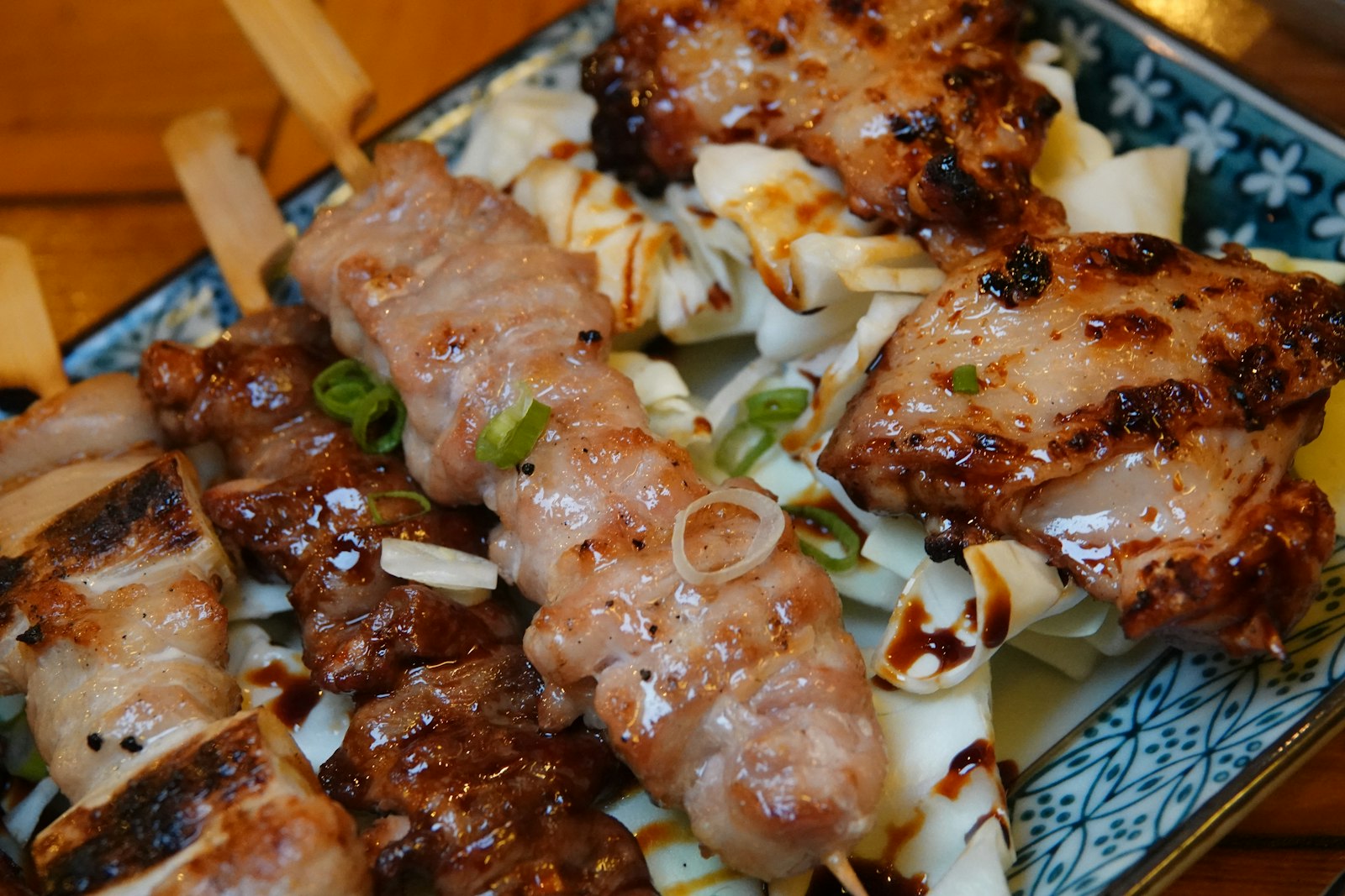 Chicken skewers grilling over charcoal at a Tokyo yakitori counter at night