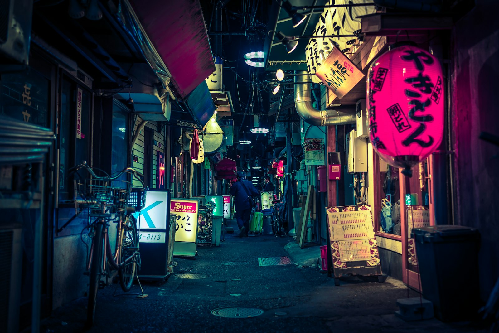 Narrow lantern-lit yokocho alley in Tokyo lined with tiny bars and izakaya at night