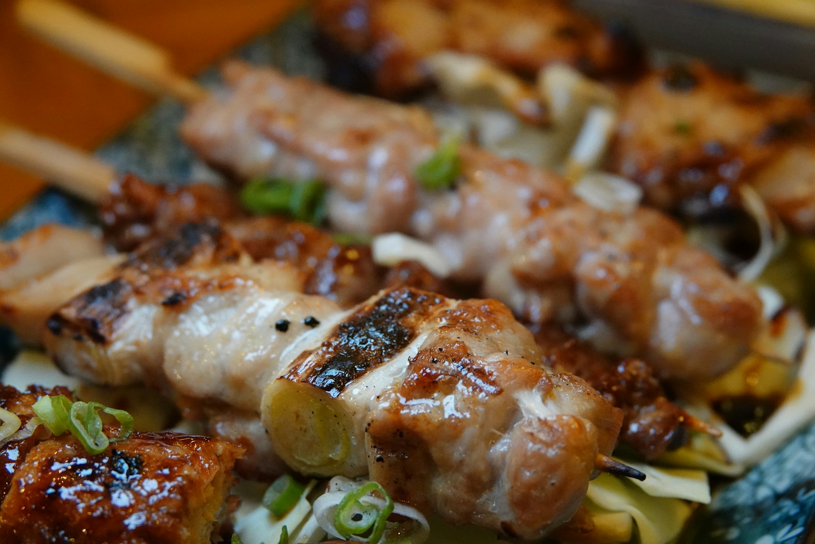 Yakitori skewers grilling over charcoal at an izakaya under the tracks in Yurakucho