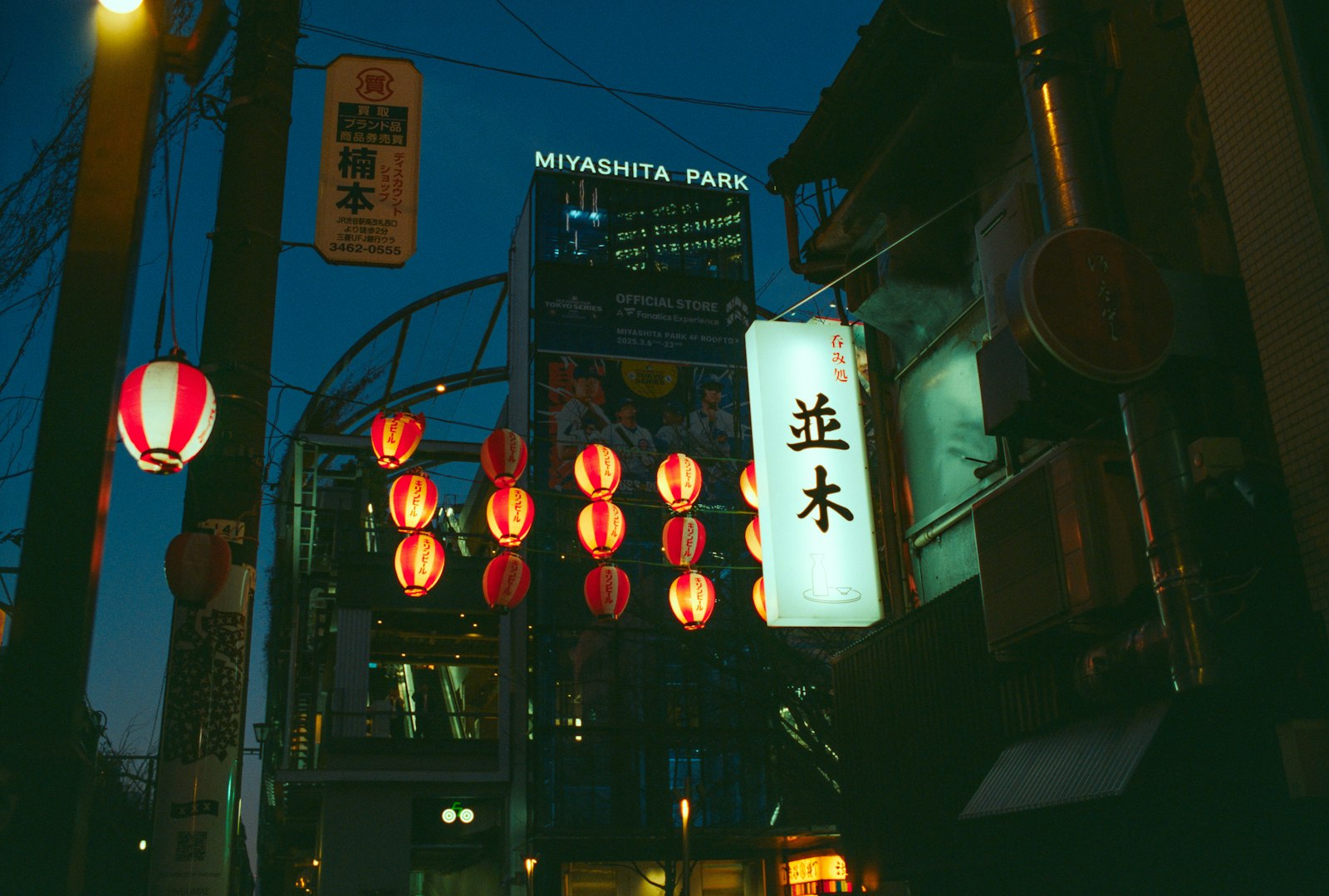 Red lanterns lining a narrow yokocho alley at night, a classic starting point for bar hopping in Tokyo