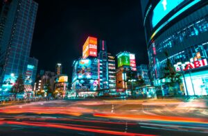 Neon signs over a busy Shinjuku street at night, one of the best hotel areas for Tokyo nightlife