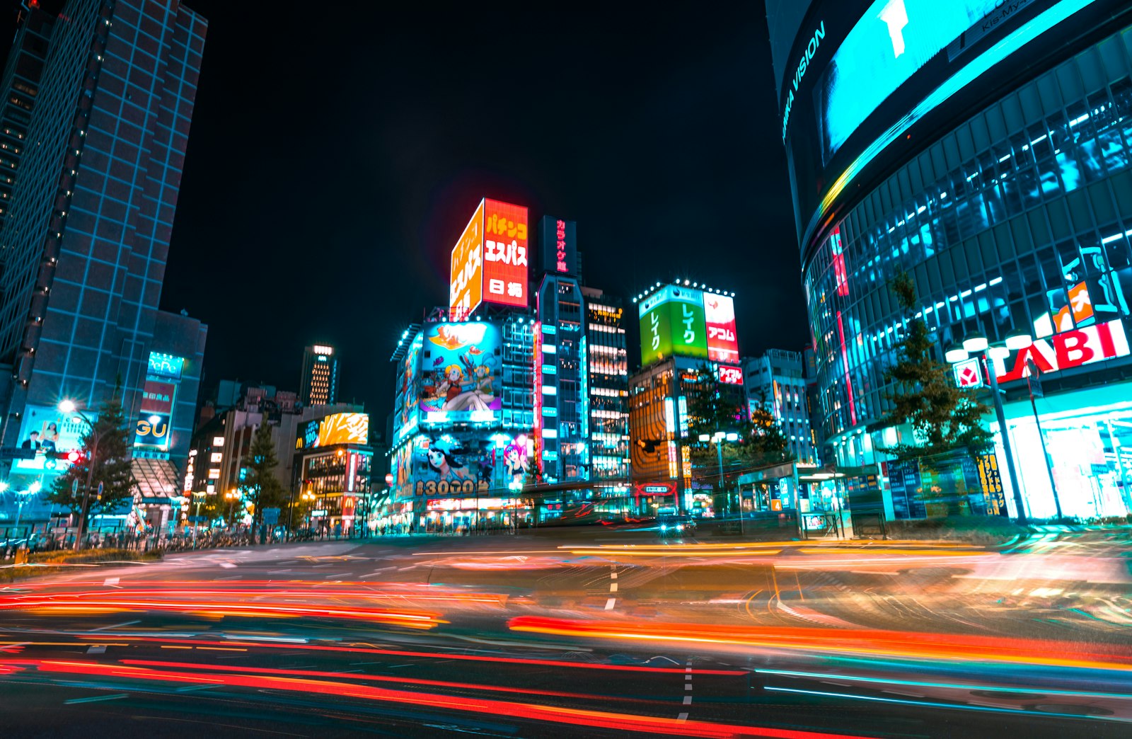 Neon signs over a busy Shinjuku street at night, one of the best hotel areas for Tokyo nightlife