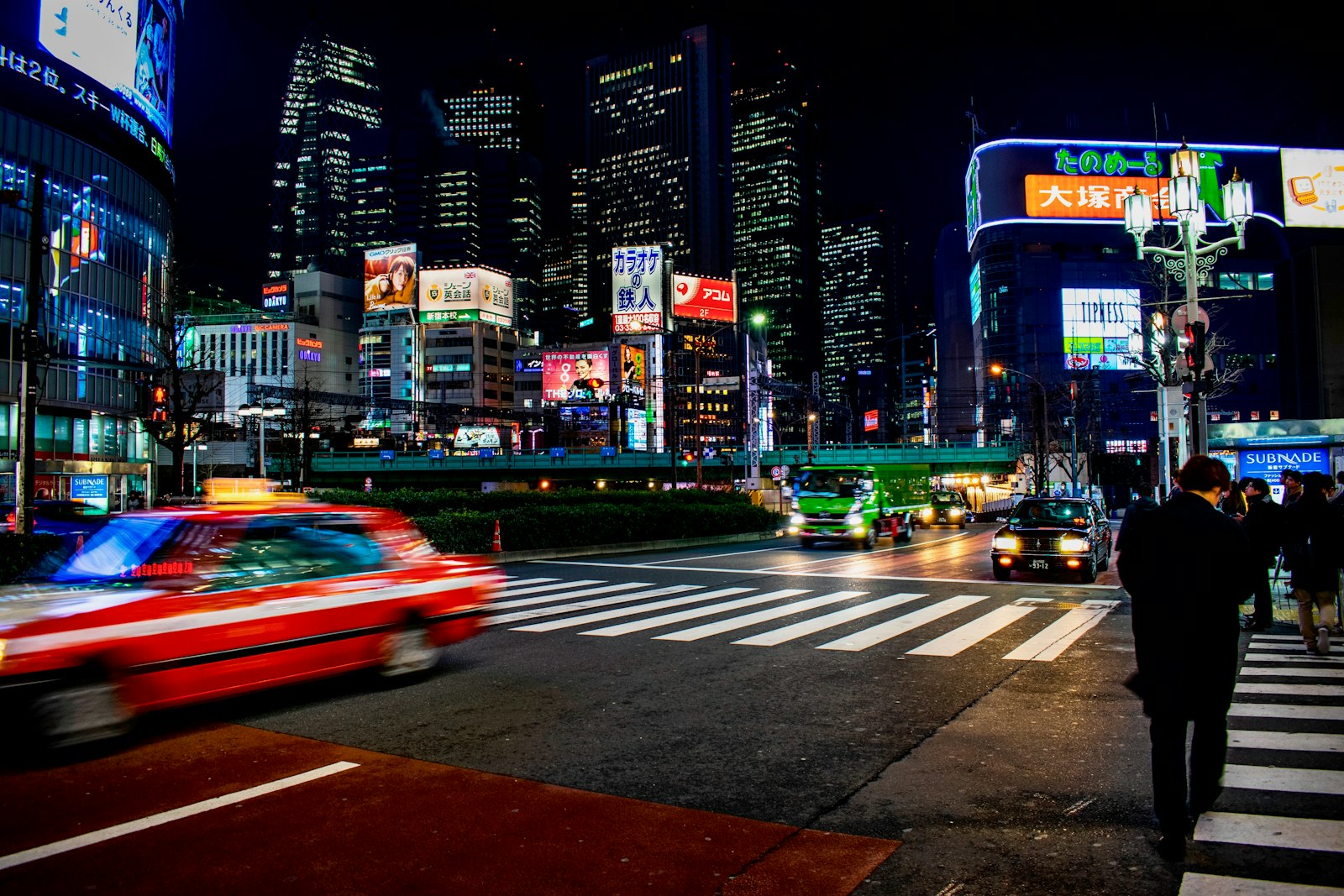 Neon-lit street in Shinjuku at night, a short walk from an evening cat cafe in Tokyo