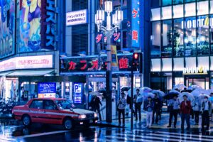 Taxis lined up on a neon-lit Tokyo street at night, the most reliable way to get around Tokyo after midnight