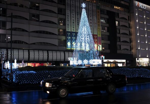Neon signs and crowds on a street near Ikebukuro Station at night