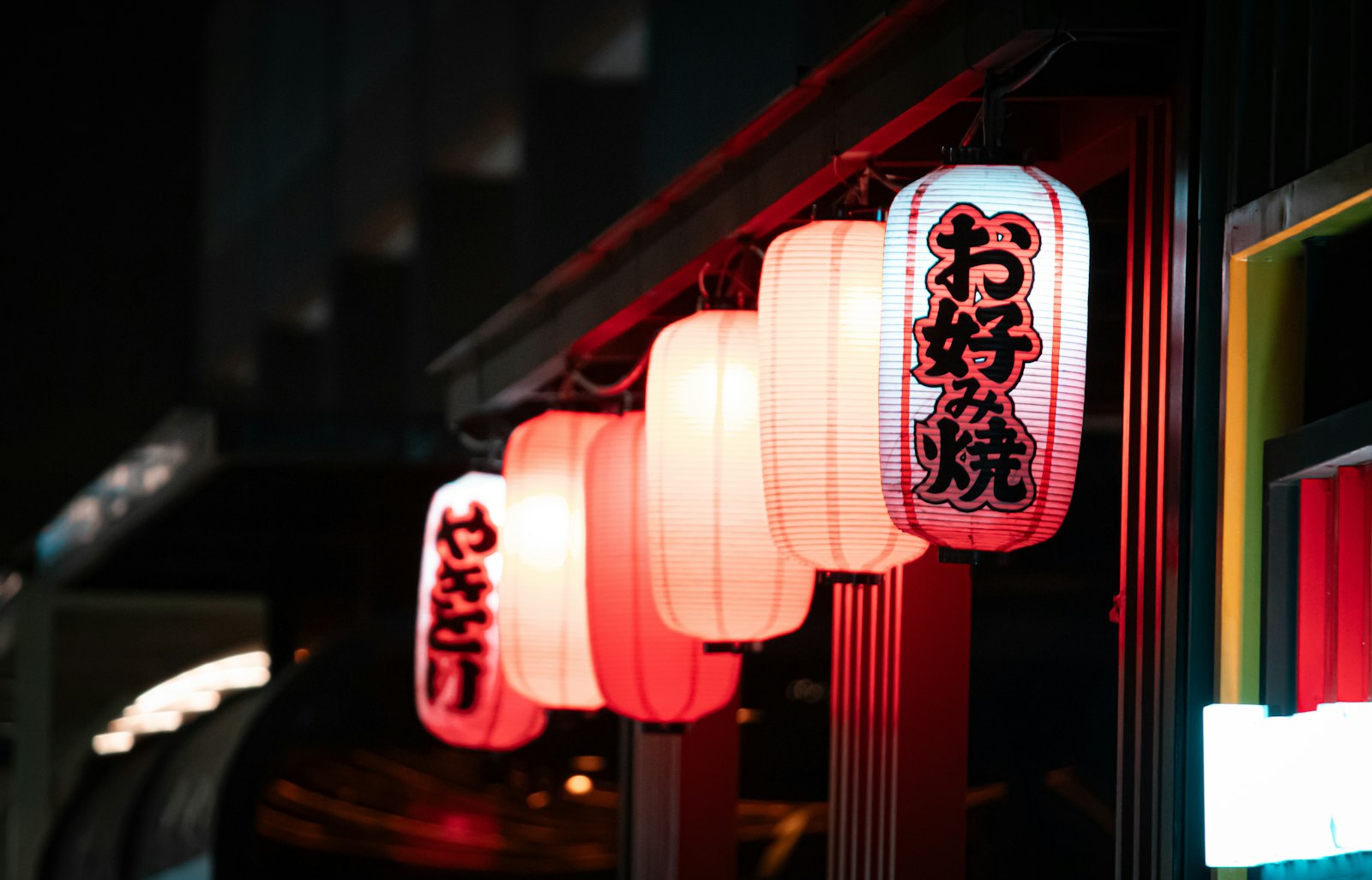 Small izakaya with red paper lanterns on a narrow back street in Tokyo at night