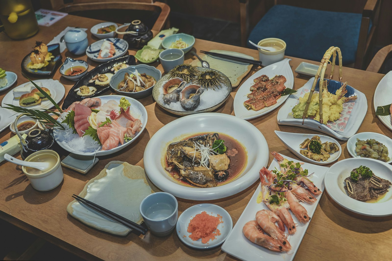 Shared plates and beer glasses on an izakaya table during a Japanese nomikai
