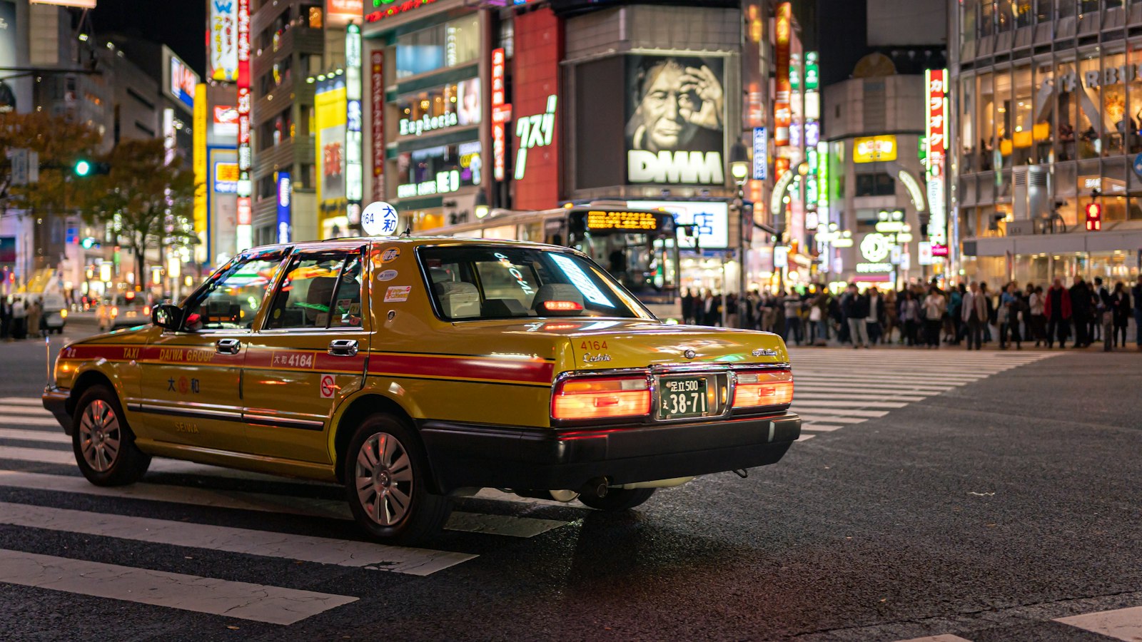 Taxi passing through Tokyo city lights late at night after a Roppongi club night