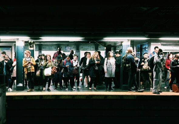 Office workers in suits gathering outside Shimbashi Station in Tokyo in the evening