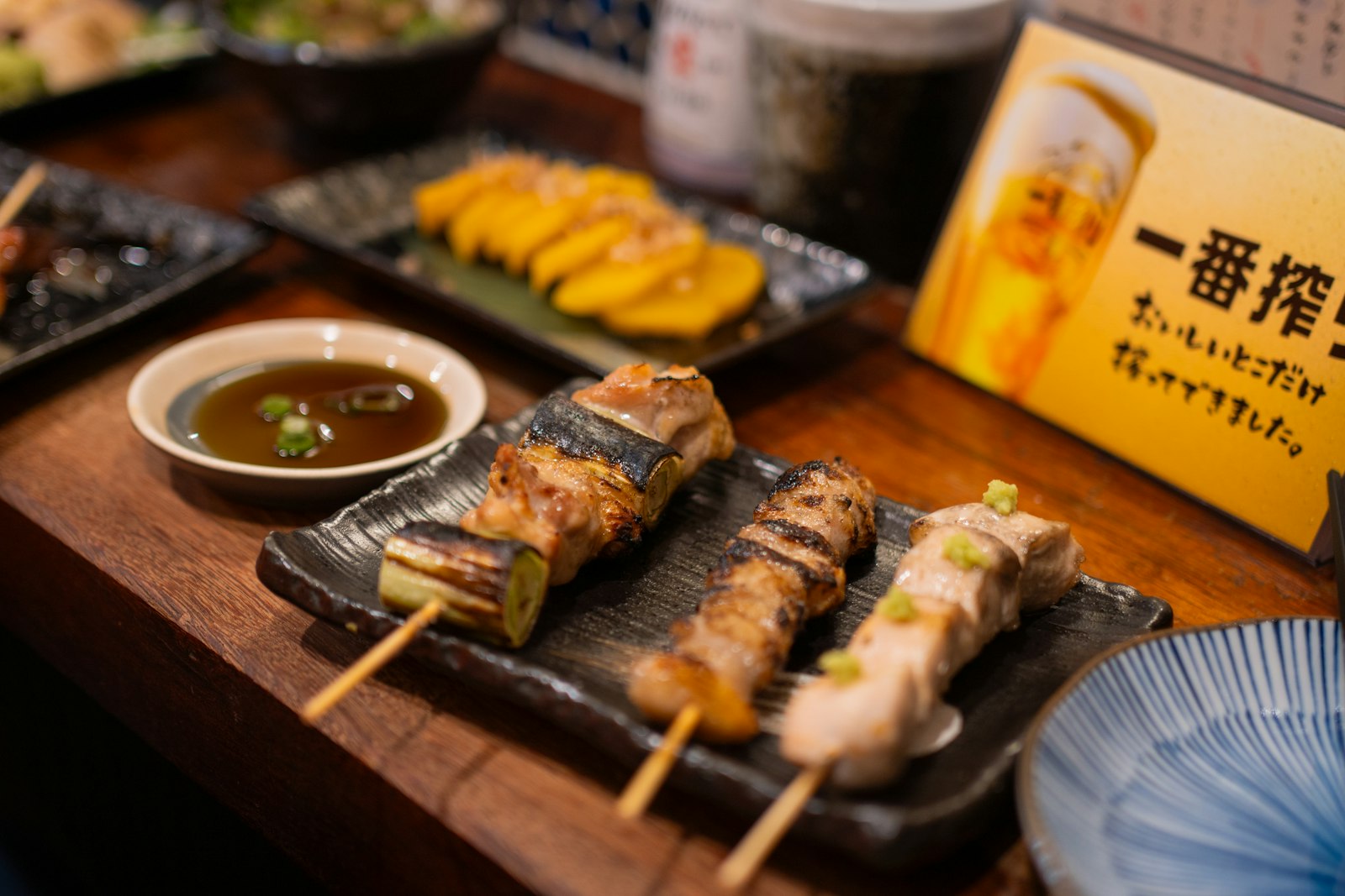 Shimbashi izakaya counter with yakitori skewers and a mug of beer