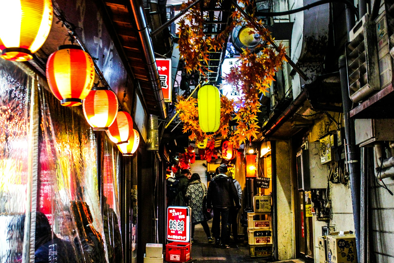 Narrow Golden Gai alley at night lit by small bar signs, a favorite stop for foreigners in Shinjuku