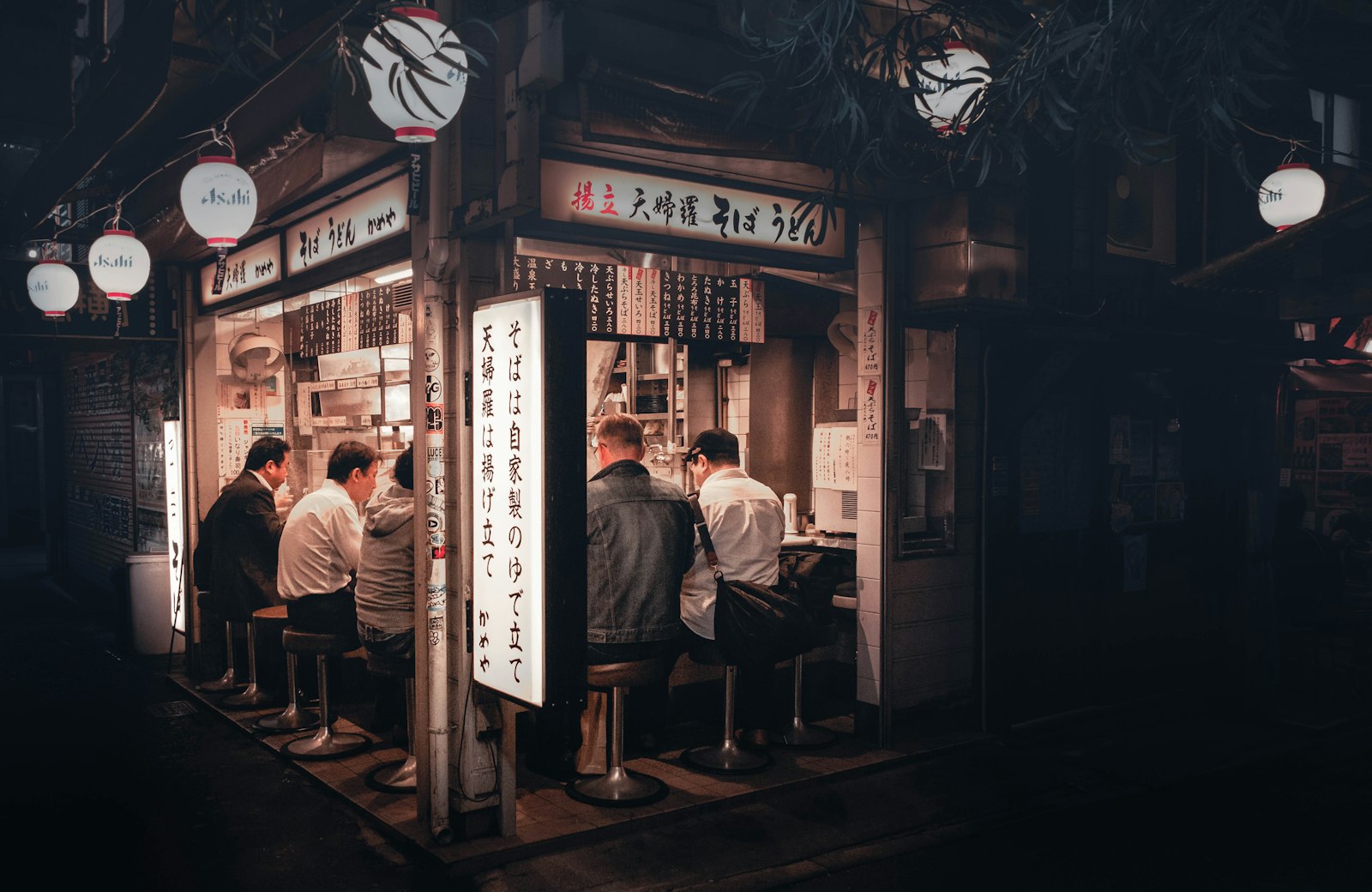 Small Golden Gai bar counter with a bartender serving a handful of guests, showing how intimate the bars are