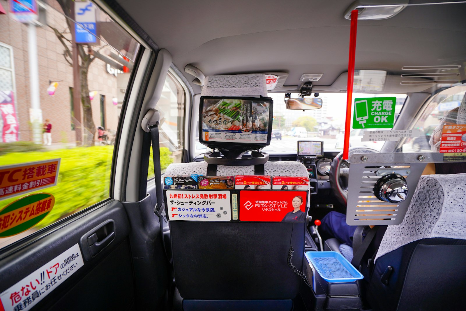 The inside of a Japanese taxi with the fare meter on the dashboard, where the late-night rate applies automatically