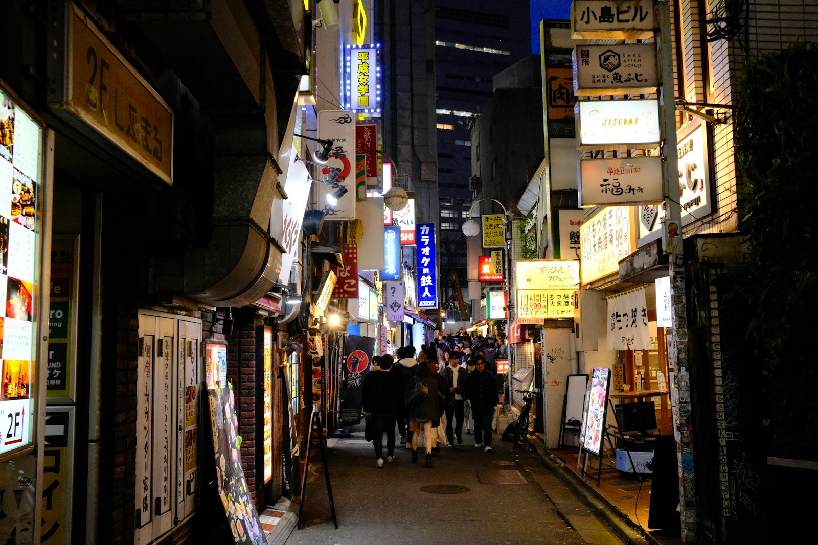 Neon-lit Tokyo nightlife street lined with small bars at night