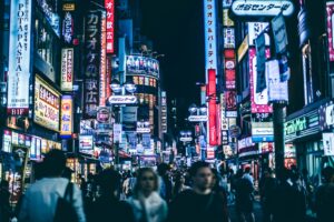 Neon-lit Shibuya street at night where many Tokyo clubs check age and ID at the door