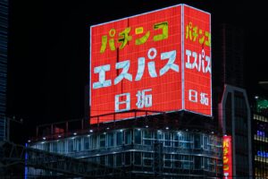 Neon signs glowing above a busy Tokyo street at night, a classic scene for Tokyo neon lights photography