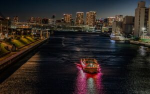 A traditional yakatabune houseboat lit with red lanterns on Tokyo Bay at night