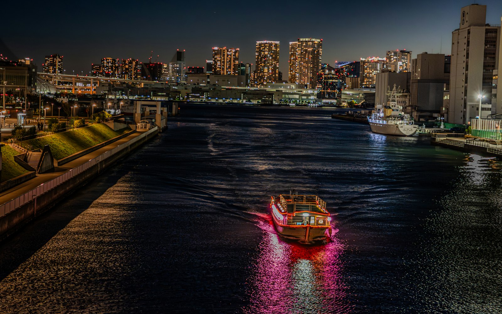 A traditional yakatabune houseboat lit with red lanterns on Tokyo Bay at night