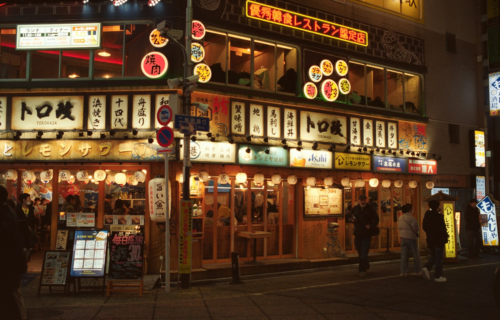 Friends sharing yakitori at an izakaya counter during a private night tour in Tokyo